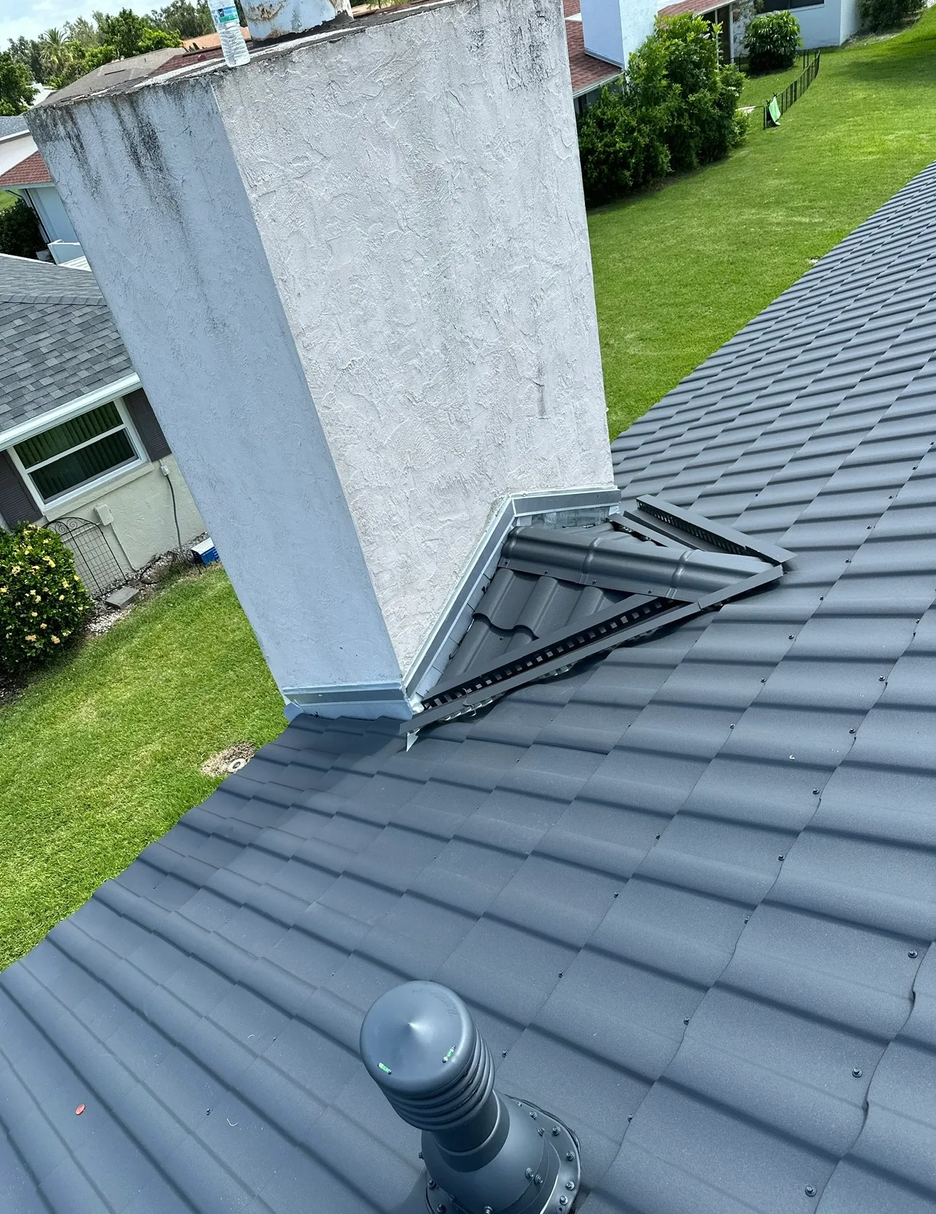 Dark asphalt shingle roof with white chimney