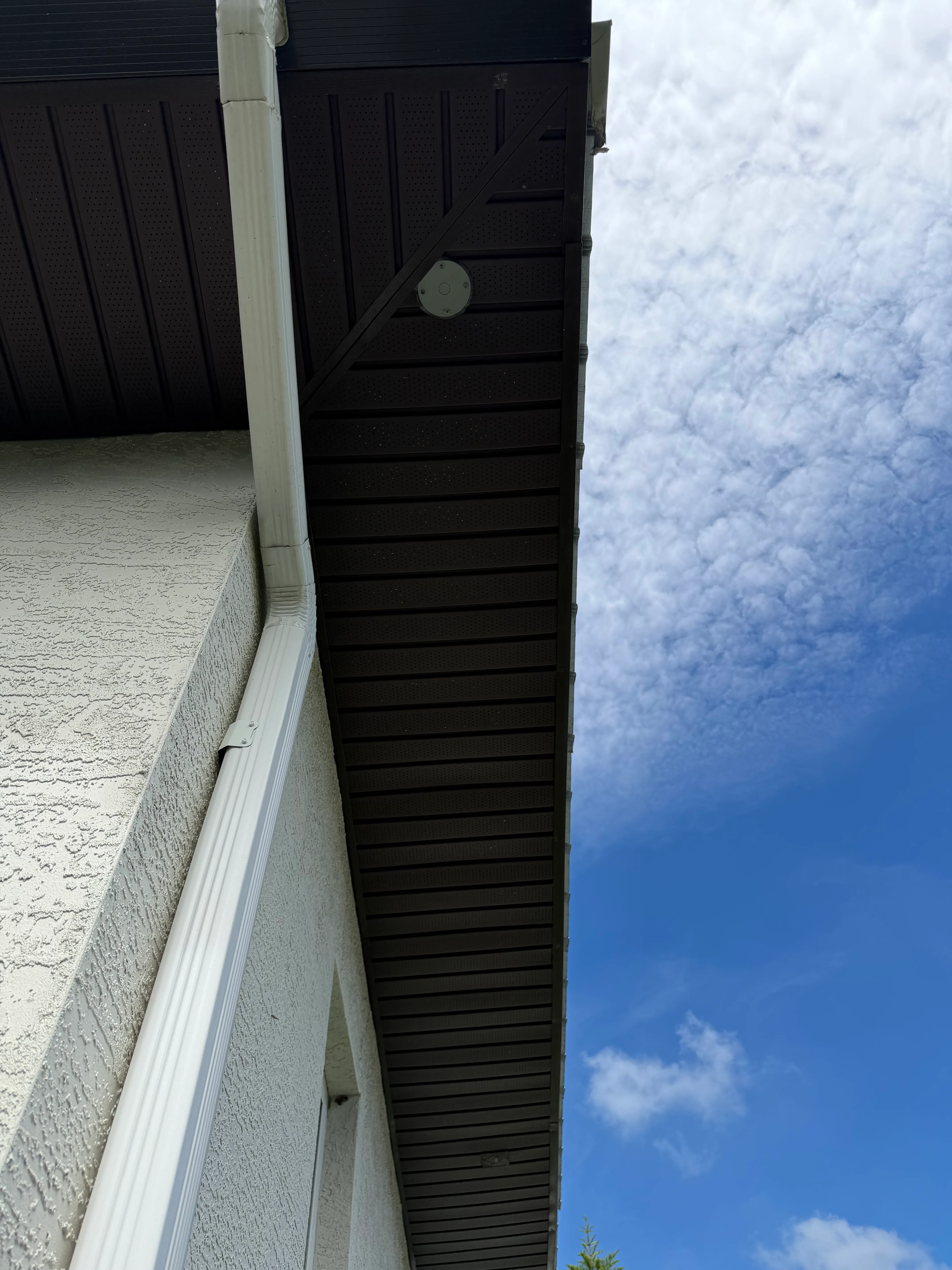 Modern building corner with dark slatted soffit detail