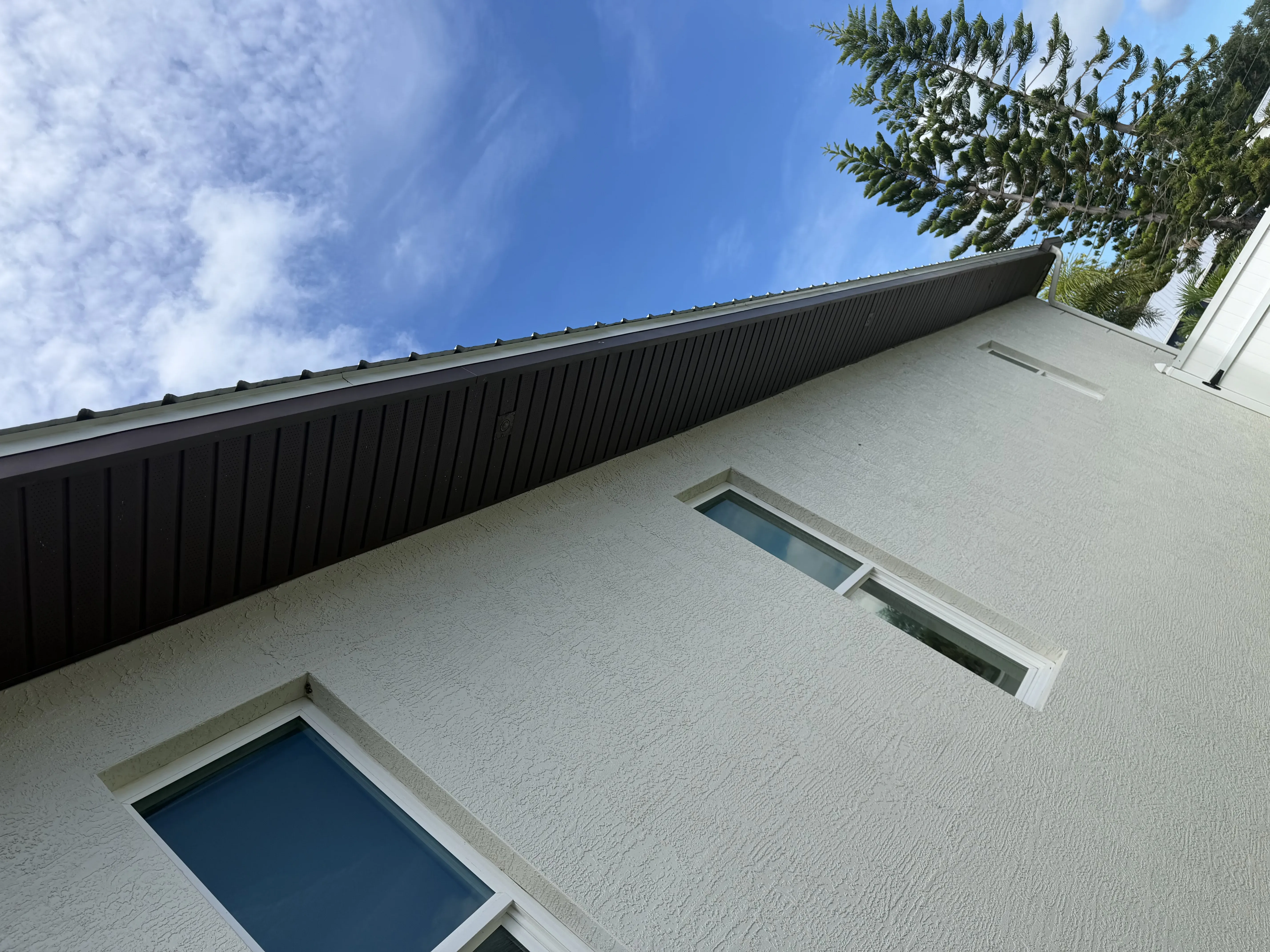 Black soffit installed under home's roofline with white exterior walls and windows
