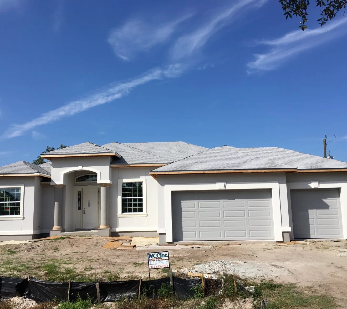New residential home with gray asphalt shingle roof and white garage
