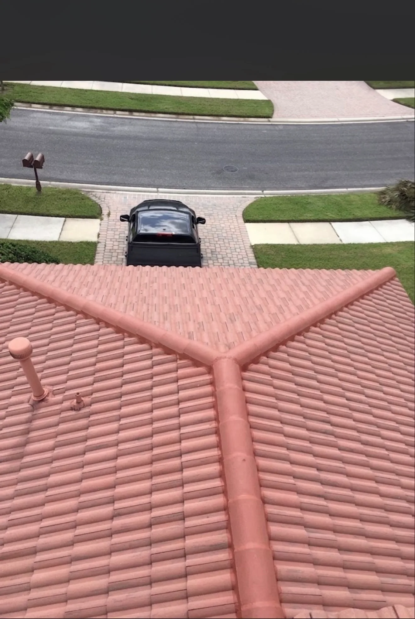 Terracotta tile roof with clay shingles and seamless gutter system detail on residential home