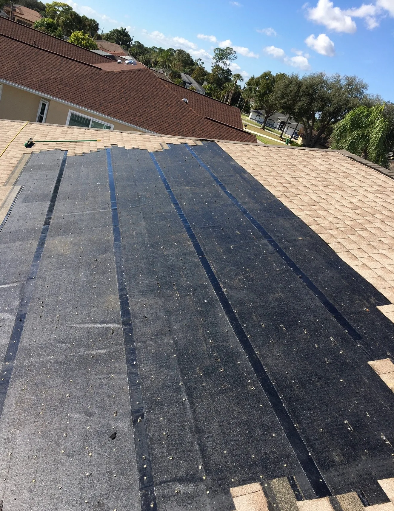Professional standing seam metal roof installation with vertical seams and black finish