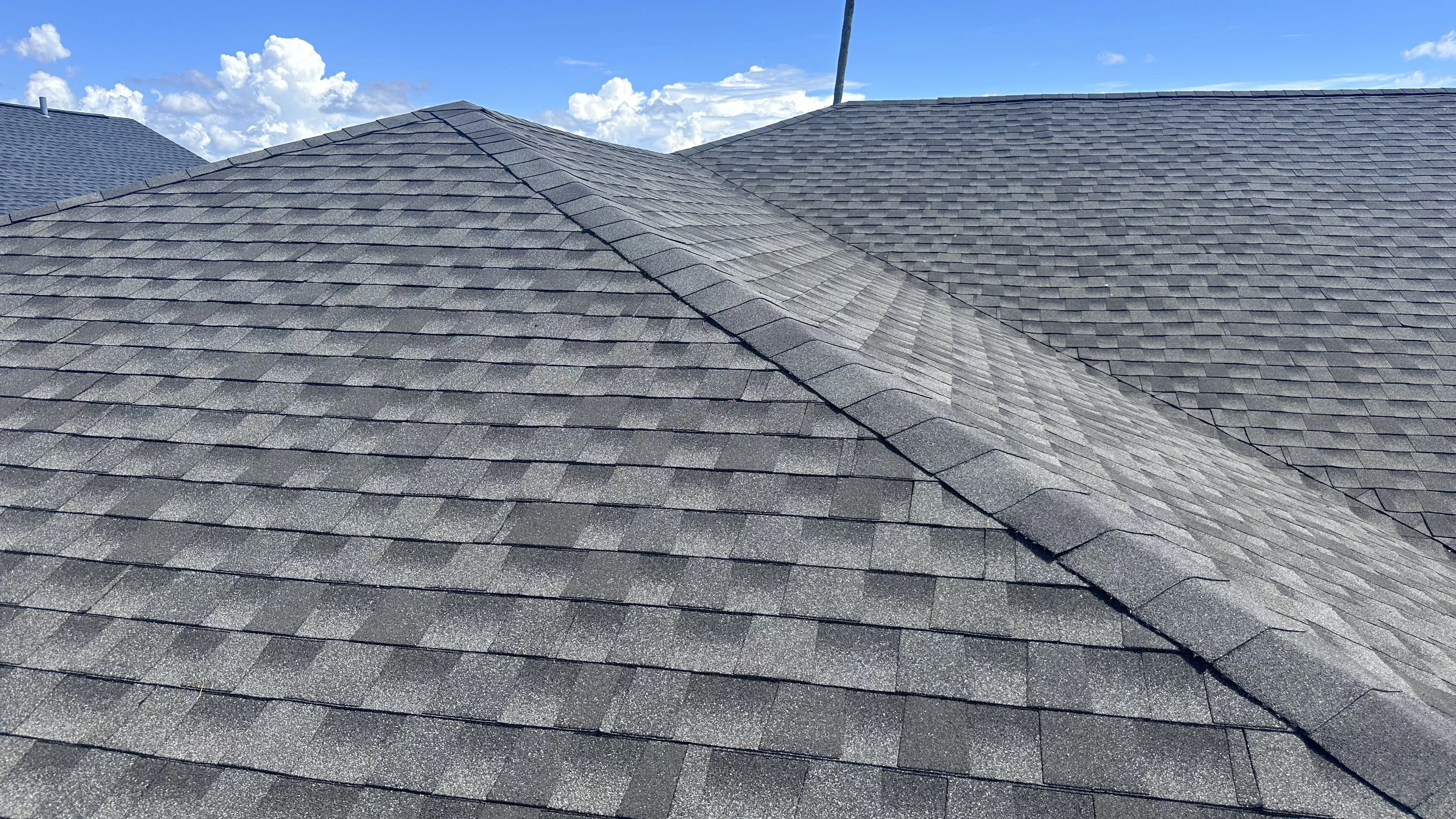Professional asphalt shingle roofing installation with clear ridge detail