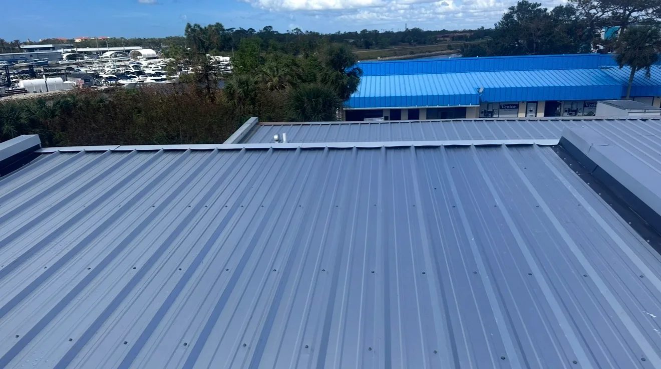 Aerial view of completed standing seam metal roof installation on commercial building