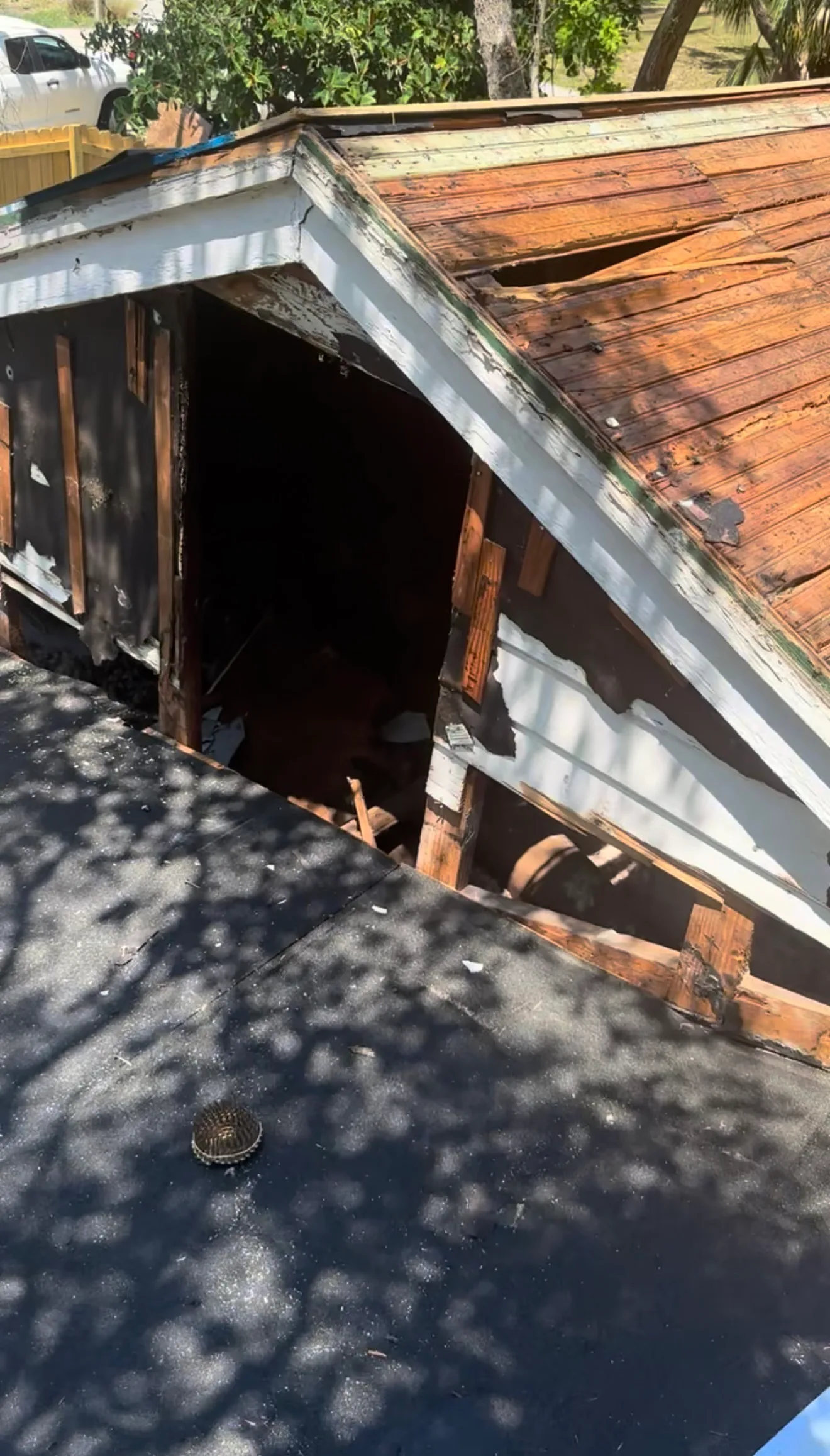 Roof replacement in progress showing exposed wooden deck with metal flashing installation