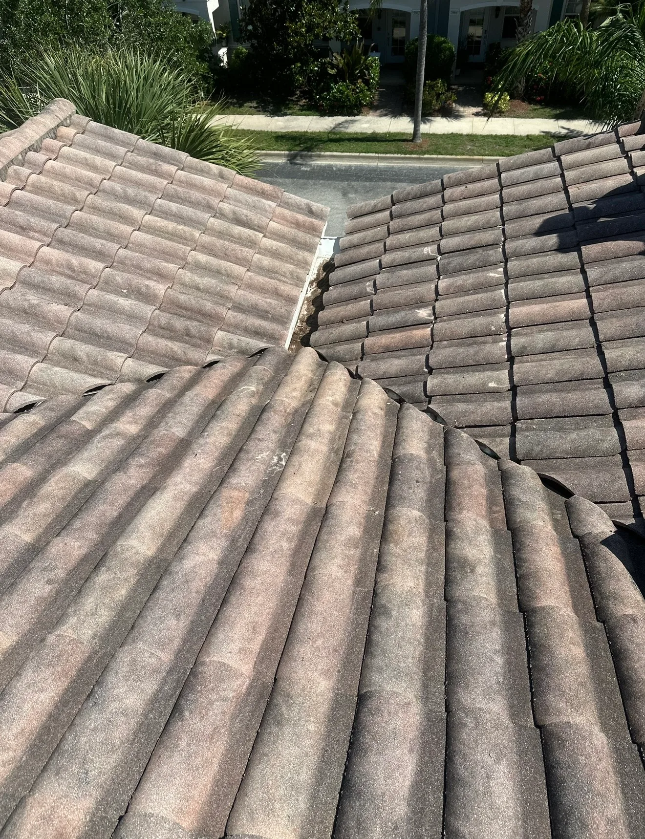 Gray ceramic tile roof showing professional installation with ridge and valley detail on residence